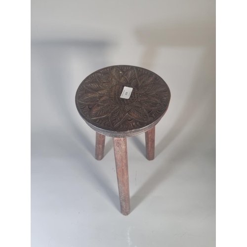 278 - A vintage carved oak tripod stool with floral design - approx. 38cm high x 22cm diameter