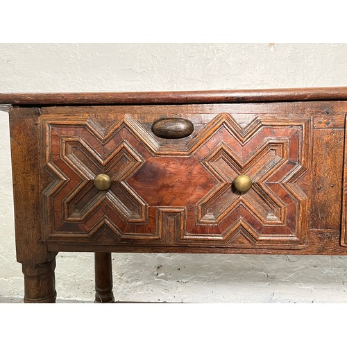 378 - A 17th century and later oak geometric moulded two drawer hall table - approx. 74cm high x 129cm wid... 