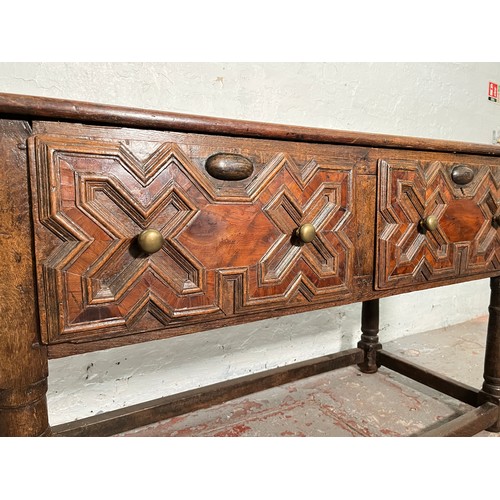 378 - A 17th century and later oak geometric moulded two drawer hall table - approx. 74cm high x 129cm wid... 