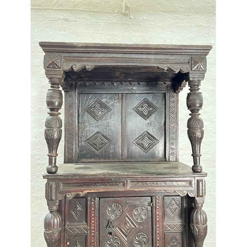 369 - An Elizabethan and later carved oak court cupboard with acanthus leaf design pillars, central cupboa... 