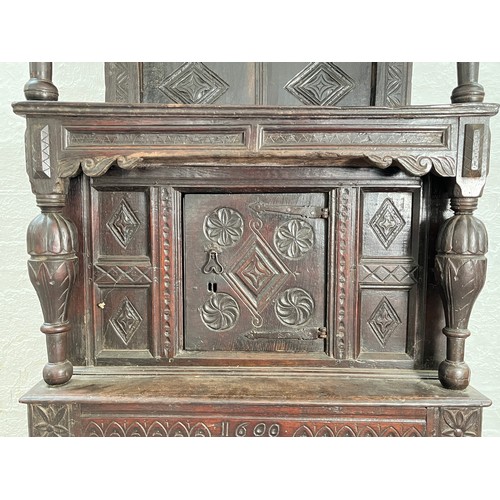 369 - An Elizabethan and later carved oak court cupboard with acanthus leaf design pillars, central cupboa... 