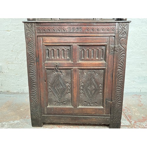 369 - An Elizabethan and later carved oak court cupboard with acanthus leaf design pillars, central cupboa... 