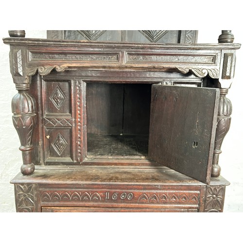 369 - An Elizabethan and later carved oak court cupboard with acanthus leaf design pillars, central cupboa... 