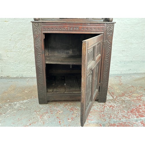 369 - An Elizabethan and later carved oak court cupboard with acanthus leaf design pillars, central cupboa... 