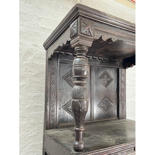 369 - An Elizabethan and later carved oak court cupboard with acanthus leaf design pillars, central cupboa... 