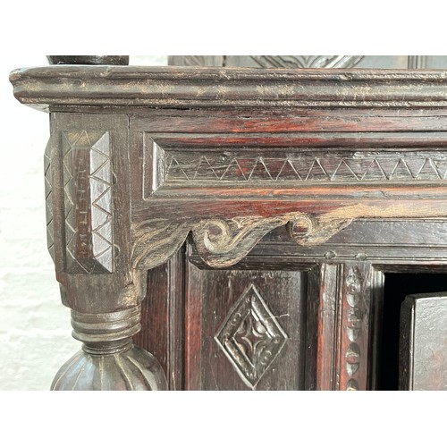 369 - An Elizabethan and later carved oak court cupboard with acanthus leaf design pillars, central cupboa... 