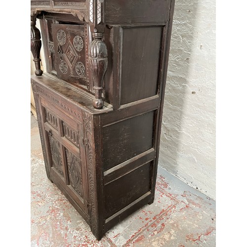 369 - An Elizabethan and later carved oak court cupboard with acanthus leaf design pillars, central cupboa... 