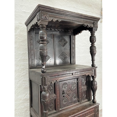 369 - An Elizabethan and later carved oak court cupboard with acanthus leaf design pillars, central cupboa... 