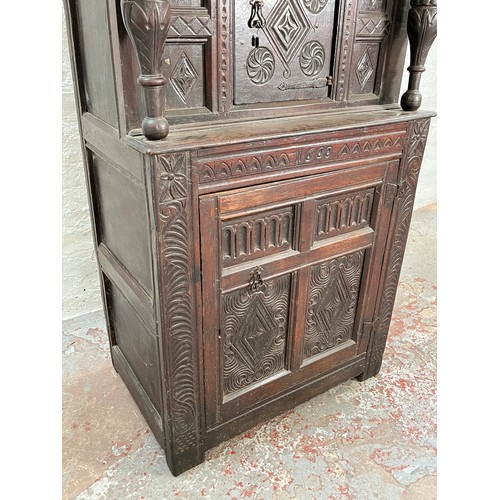 369 - An Elizabethan and later carved oak court cupboard with acanthus leaf design pillars, central cupboa... 