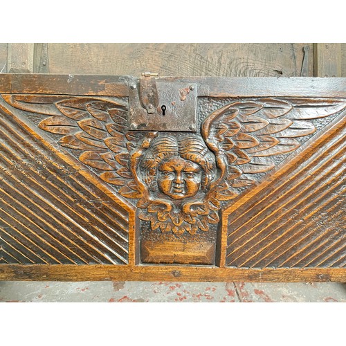 404 - A 17th century oak sword chest with carved cherub design - approx. 56.5cm high x 112cm wide x 39cm d... 