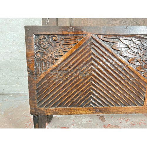 404 - A 17th century oak sword chest with carved cherub design - approx. 56.5cm high x 112cm wide x 39cm d... 