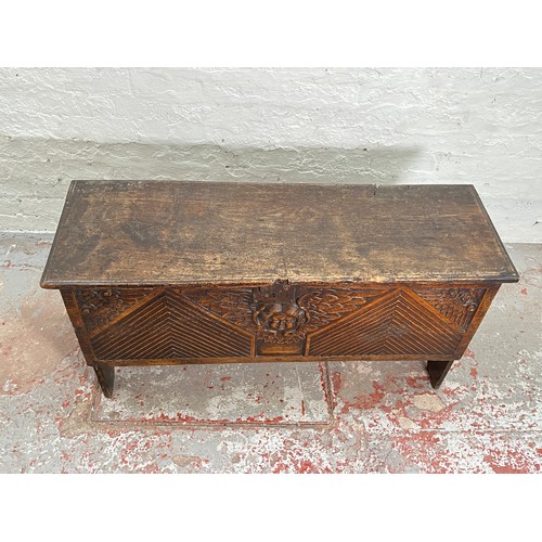 404 - A 17th century oak sword chest with carved cherub design - approx. 56.5cm high x 112cm wide x 39cm d... 