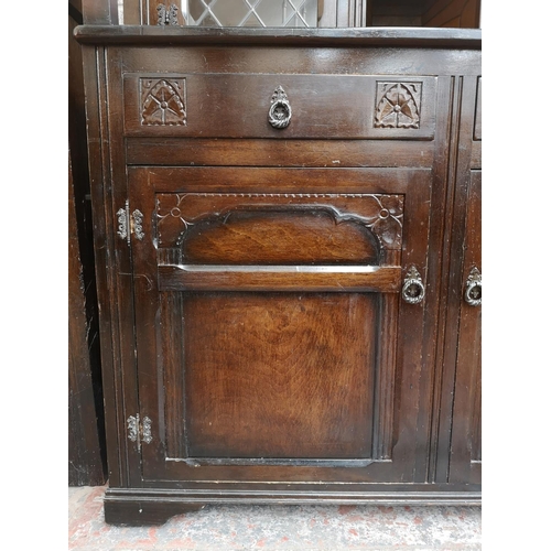 310 - A mid/late 20th century oak court cupboard with two upper leaded glass doors, two drawers and two lo... 