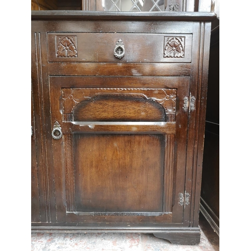 310 - A mid/late 20th century oak court cupboard with two upper leaded glass doors, two drawers and two lo... 