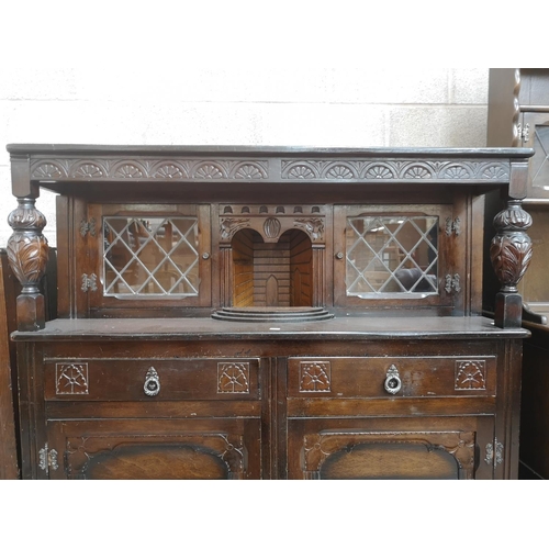 310 - A mid/late 20th century oak court cupboard with two upper leaded glass doors, two drawers and two lo... 