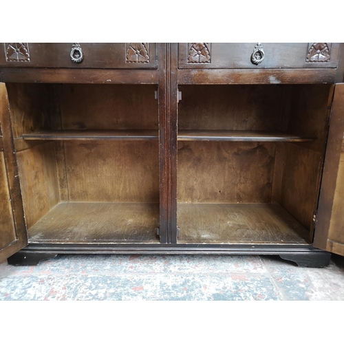 310 - A mid/late 20th century oak court cupboard with two upper leaded glass doors, two drawers and two lo... 