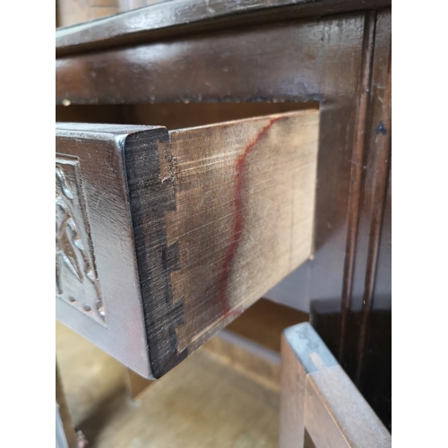 310 - A mid/late 20th century oak court cupboard with two upper leaded glass doors, two drawers and two lo... 