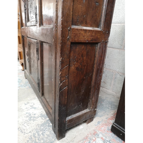 311 - A 17th century oak two door cupboard with Tudor Rose design - approx. 112cm high x 112cm wide x 31cm... 