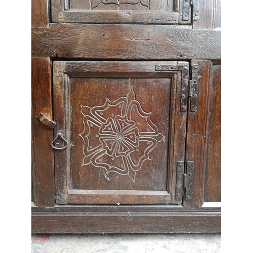 311 - A 17th century oak two door cupboard with Tudor Rose design - approx. 112cm high x 112cm wide x 31cm... 