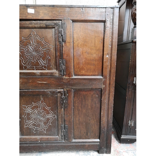 311 - A 17th century oak two door cupboard with Tudor Rose design - approx. 112cm high x 112cm wide x 31cm... 