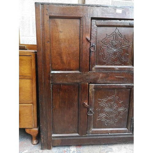 311 - A 17th century oak two door cupboard with Tudor Rose design - approx. 112cm high x 112cm wide x 31cm... 