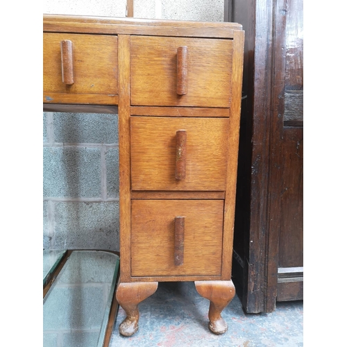 313 - An Art Deco oak dressing table with six short drawers, one long drawer, upper three section mirror a... 