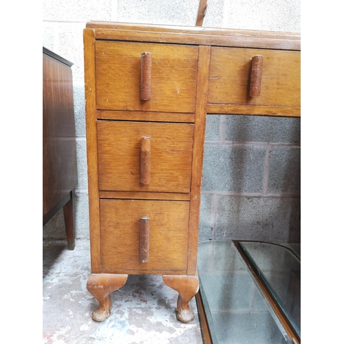 313 - An Art Deco oak dressing table with six short drawers, one long drawer, upper three section mirror a... 