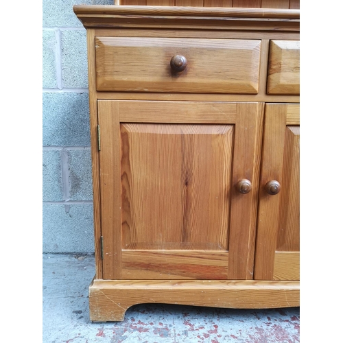 315 - A modern pine Welsh dresser with upper two tier plate rack, two drawers and two lower cupboard doors... 