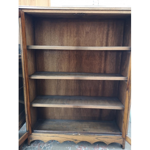 323 - A mid 20th century oak two door glazed bookcase with three internal shelves - approx. 122.5cm high x... 