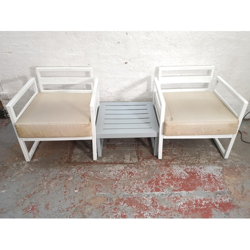 339 - Two Siesta white plastic outdoor armchairs and one Siesta grey plastic side table