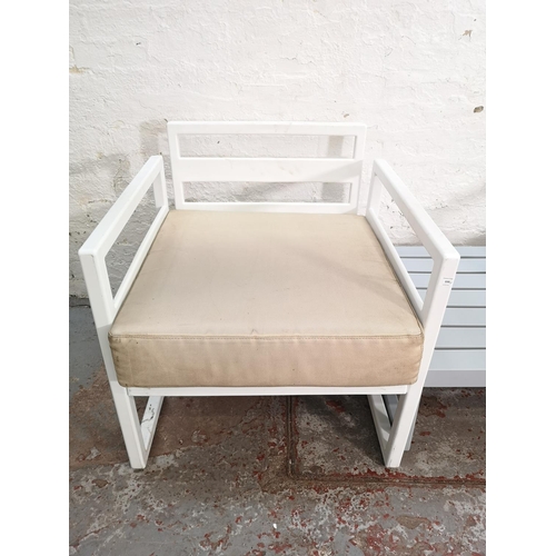 339 - Two Siesta white plastic outdoor armchairs and one Siesta grey plastic side table