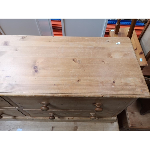 354 - A modern solid pine low chest of four drawers - approx. 57cm high x 135cm wide x 39cm deep