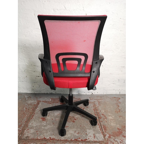 411 - A modern black plastic and red woven swivel office desk chair