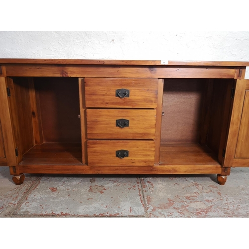 414 - A modern hardwood sideboard with two outer cupboard doors and three central drawers - approx. 81cm h... 