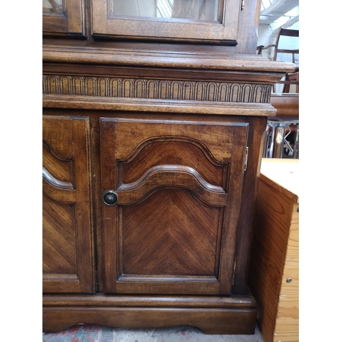 418 - A late 20th century oak display cabinet with two upper glazed doors and two lower cupboard doors - a... 