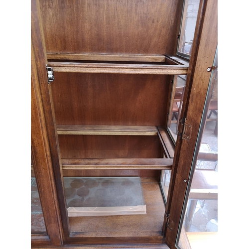 418 - A late 20th century oak display cabinet with two upper glazed doors and two lower cupboard doors - a... 