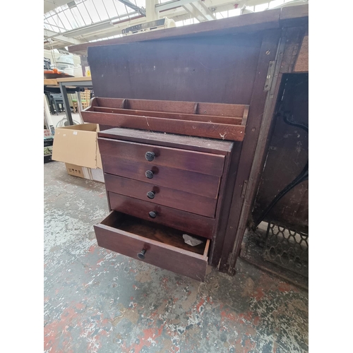 790 - An early 20th century mahogany sewing machine cabinet containing Singer treadle sewing machine (seri... 