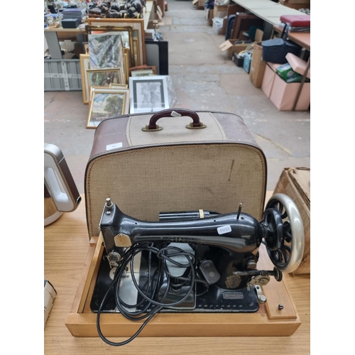 785 - A cased Singer electric sewing machine with light and foot pedal