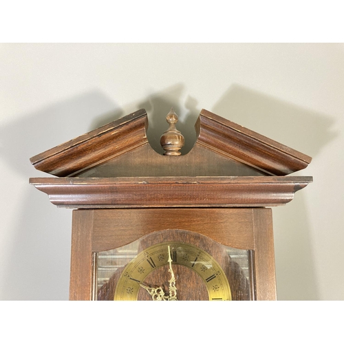 261 - A late 20th century mahogany cased wall clock with pendulum and key - approx. 71cm high x 33cm wide ... 