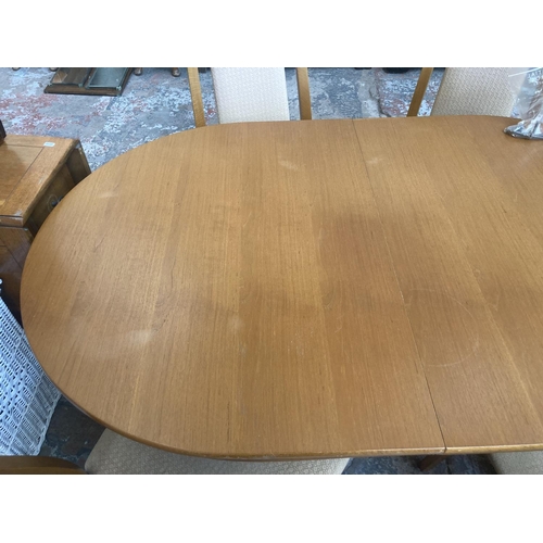 337 - A mid/late 20th century teak twin pedestal extending oval dining table and six beech and beige uphol... 