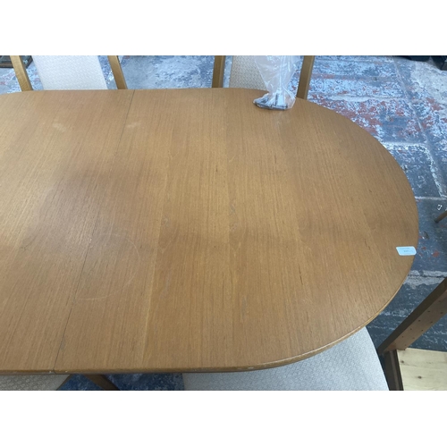 337 - A mid/late 20th century teak twin pedestal extending oval dining table and six beech and beige uphol... 