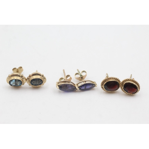 1083 - Three pairs of 9ct gold stud earrings, one iolite, one topaz and one garnet - approx. gross weight 5... 