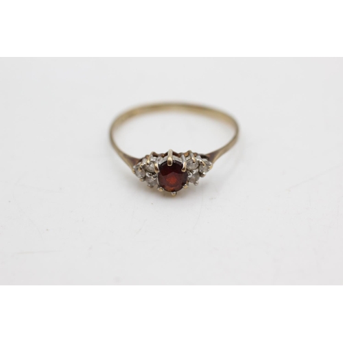 1087 - A 9ct gold garnet and clear gemstone dress ring, size P½ - approx. gross weight 1.1 grams