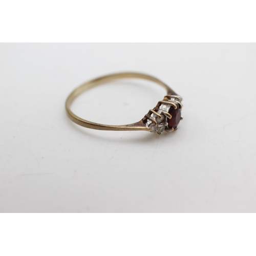 1087 - A 9ct gold garnet and clear gemstone dress ring, size P½ - approx. gross weight 1.1 grams