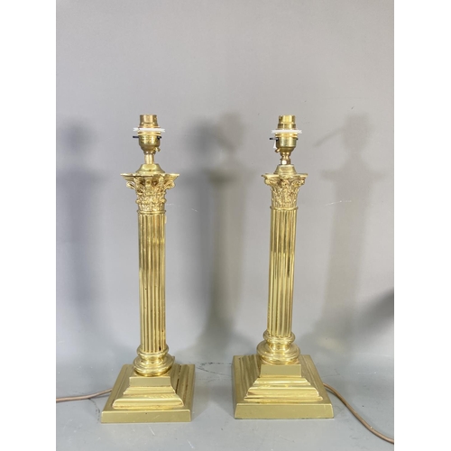 214 - Three brass lighting items, a pair of corinthian columned table lamps approx. 44cm high and wall mou... 