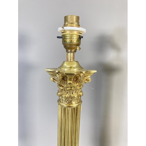 214 - Three brass lighting items, a pair of corinthian columned table lamps approx. 44cm high and wall mou... 