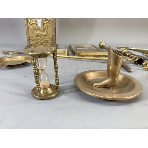 215 - A collection of brassware to include wall mountable letter rack, ashtray, companion set holder etc.