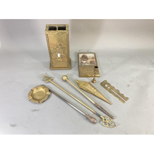 215 - A collection of brassware to include wall mountable letter rack, ashtray, companion set holder etc.