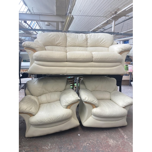 4 - A modern cream leather and beech three piece lounge suite comprising three seater sofa and two armch... 