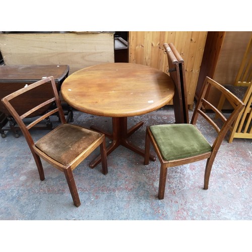 39 - A teak circular extending dining table and two 1950s oak dining chairs - approx. 72cm high x 99cm di... 
